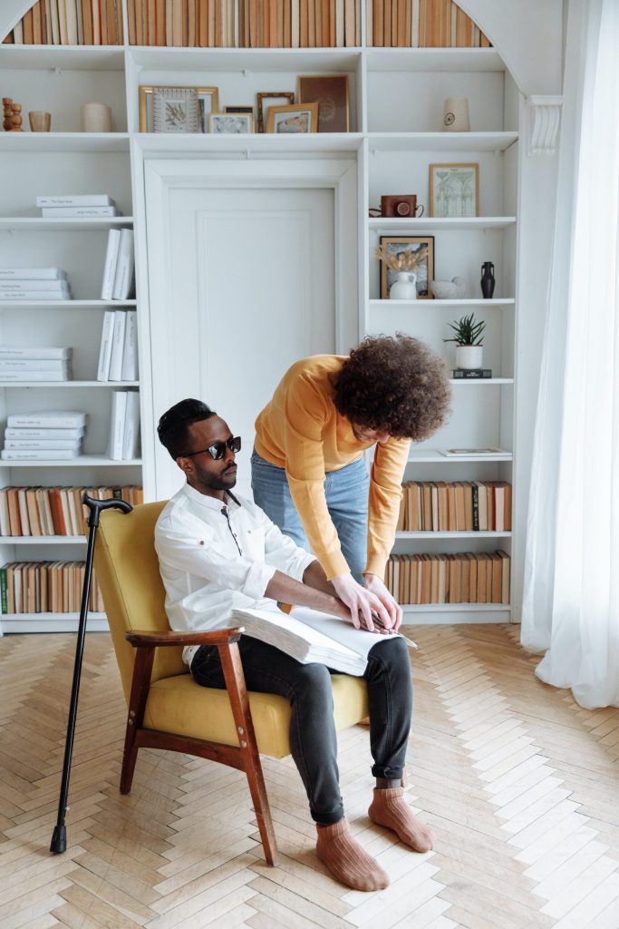 A Support a Blind Man using a Braille Book